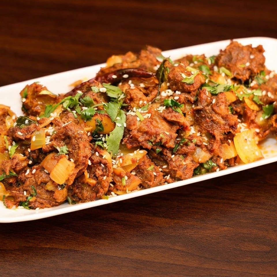 Spiced crispy fritters topped with sesame seeds, cilantro, and diced vegetables on a white rectangular plate.